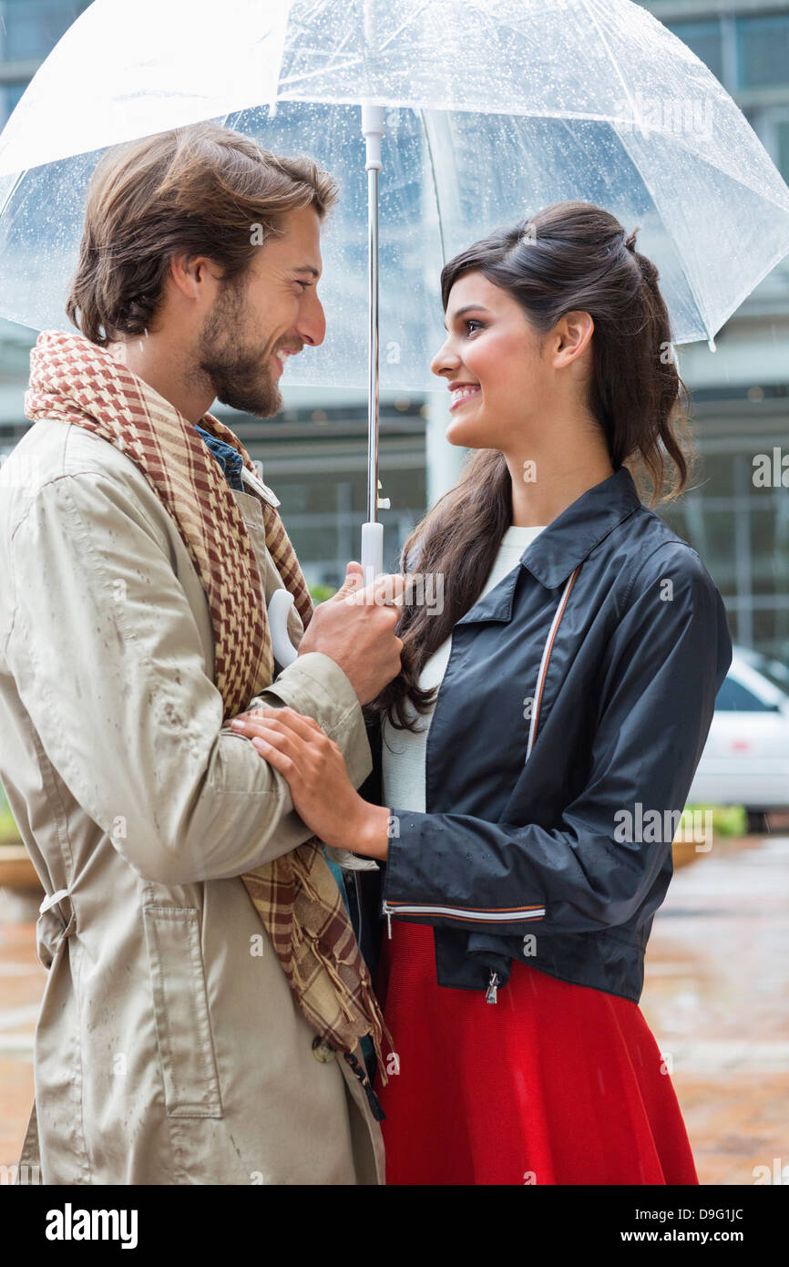 Smiling couple under an umbrella Stock Photo - Alamy