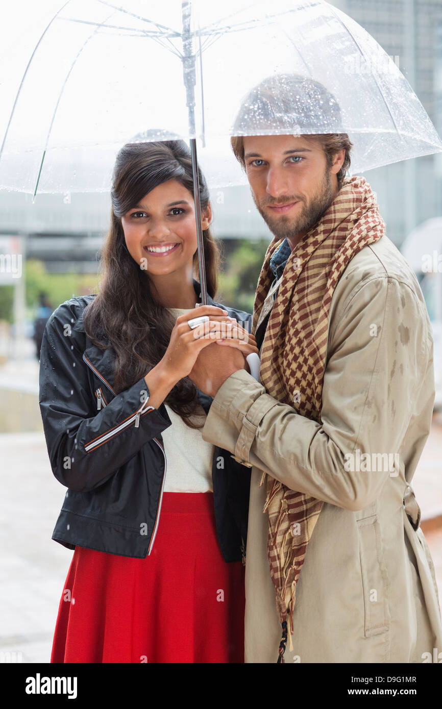 Portrait of a smiling couple under an umbrella Stock Photo - Alamy