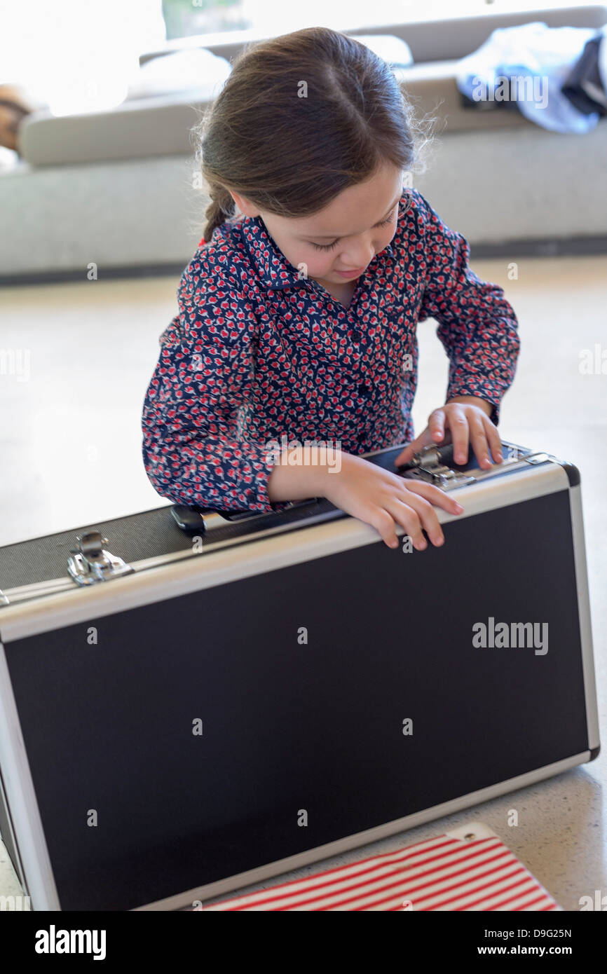 Girl trying to close a suitcase Stock Photo Alamy