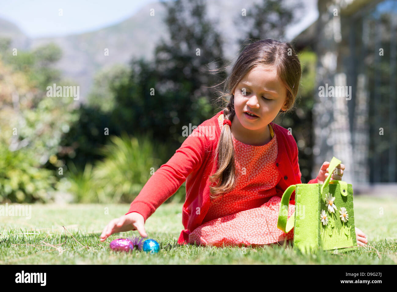 Girl picking up Easter eggs in a lawn Stock Photo Alamy
