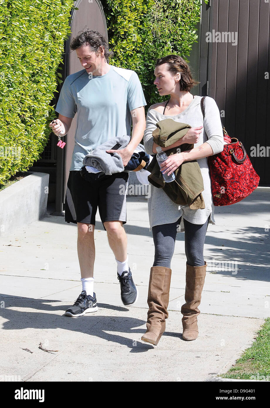 Milla Jovovich wearing brown knee length boots and t-shirt, leaving the