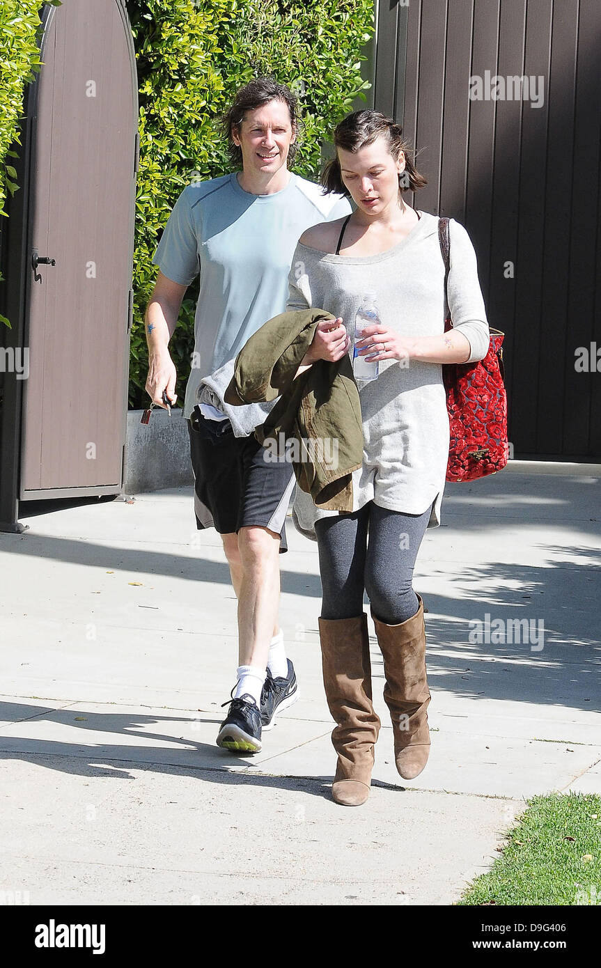 Milla Jovovich wearing brown knee length boots and t-shirt, leaving the