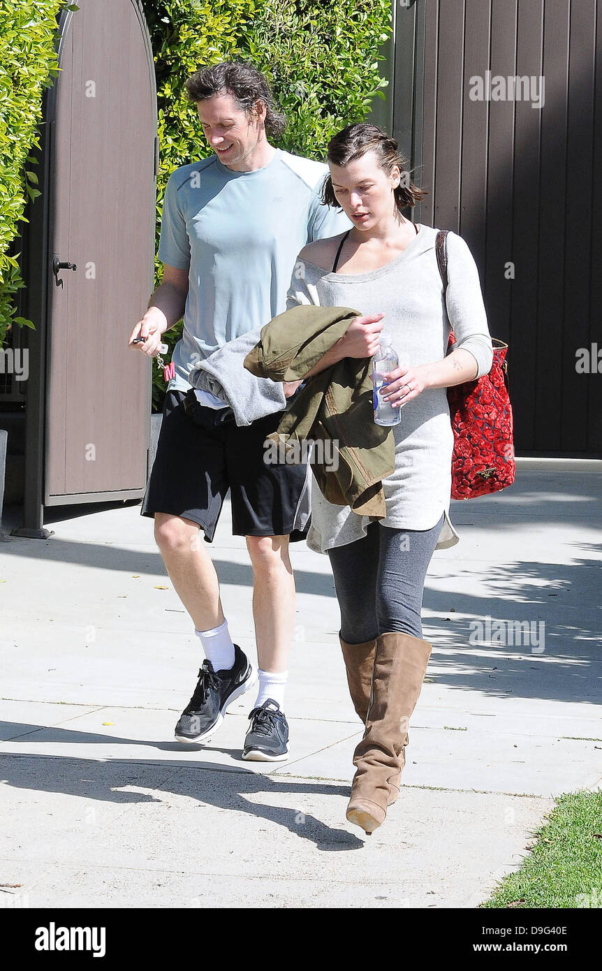 Milla Jovovich wearing brown knee length boots and t-shirt, leaving the