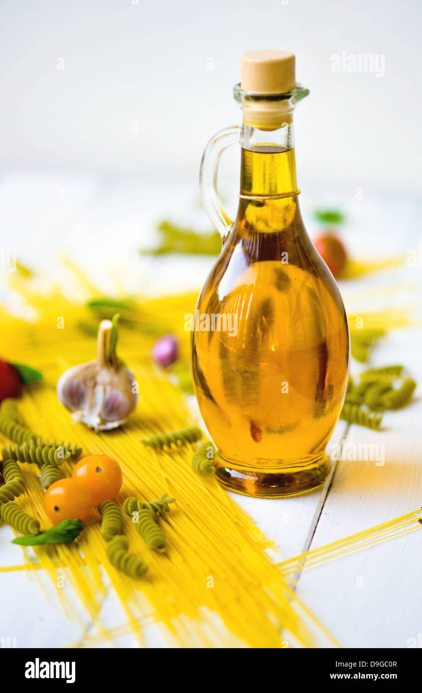 A bottle of extra virgin olive oil and pasta with yellow cherry