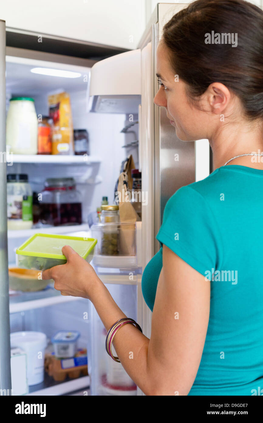 Woman putting food in a refrigerator Stock Photo Alamy