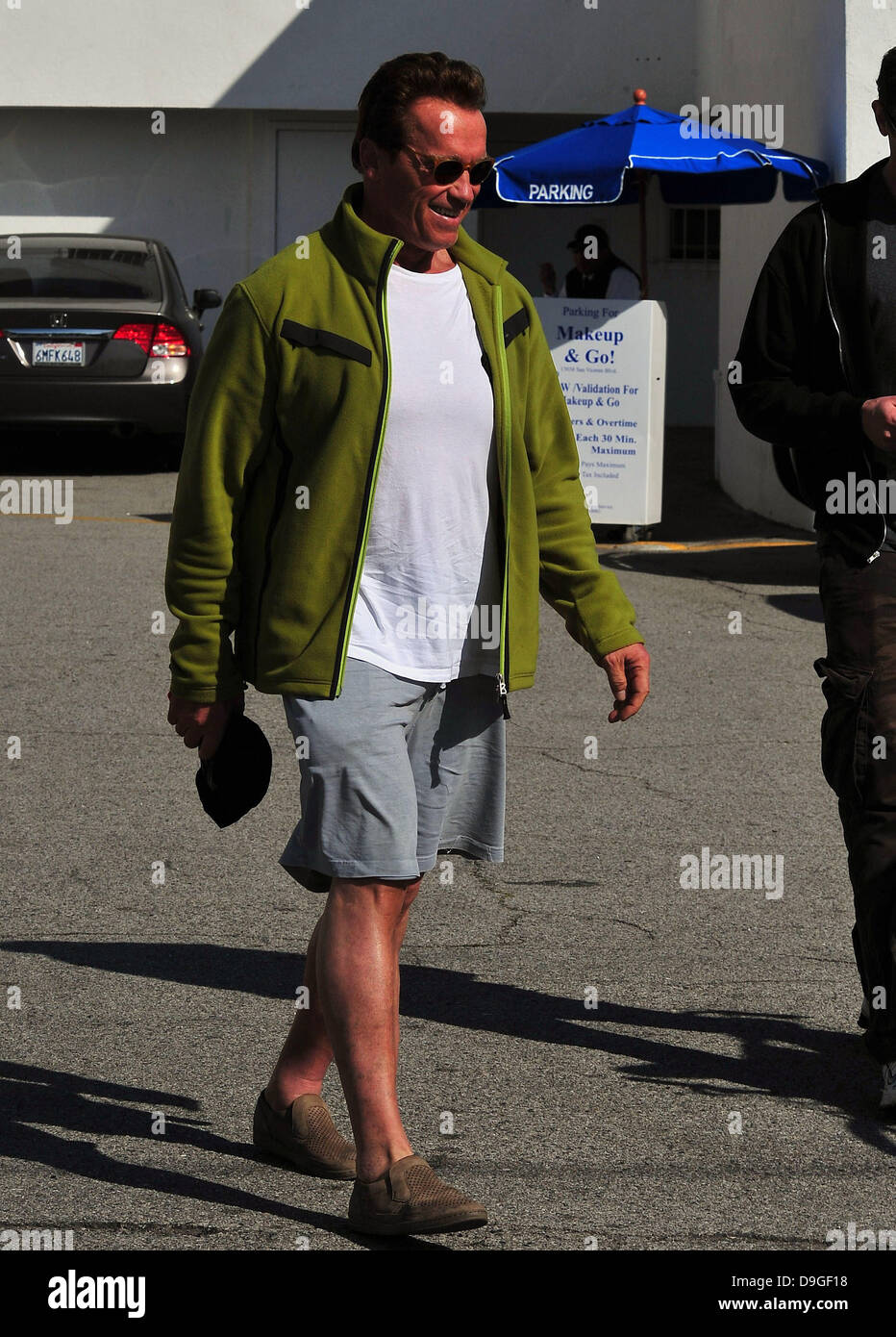 Arnold Schwarzenegger at the Brentwood Country Mart, wearing a green fleece  jacket with knee-length shorts, and slip-on shoes Brentwood, California -  15.03.11 Stock Photo - Alamy