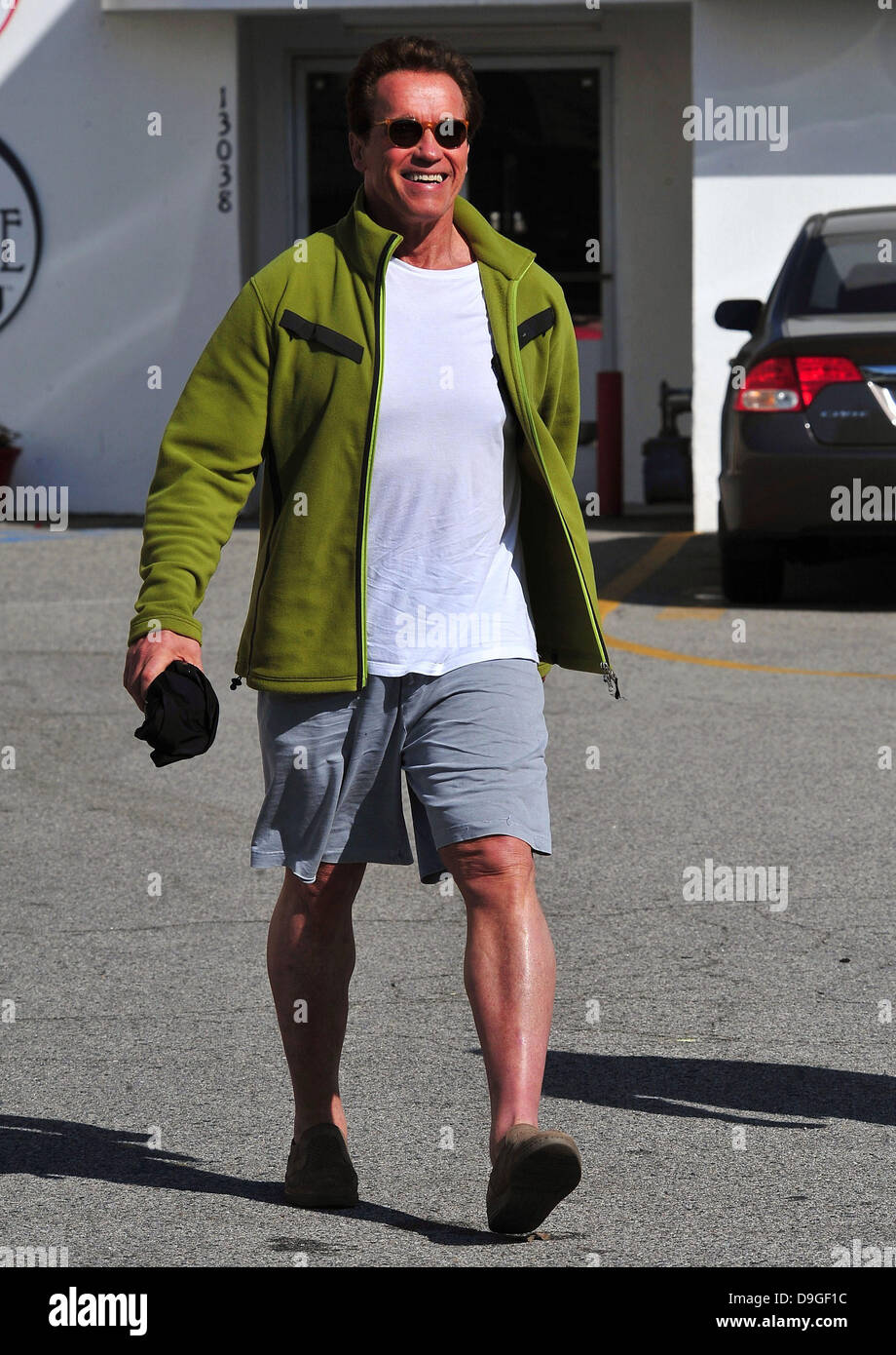 Arnold Schwarzenegger  at the Brentwood Country Mart, wearing a green fleece jacket with knee-length shorts, and slip-on shoes  Brentwood, California - 15.03.11 Stock Photo