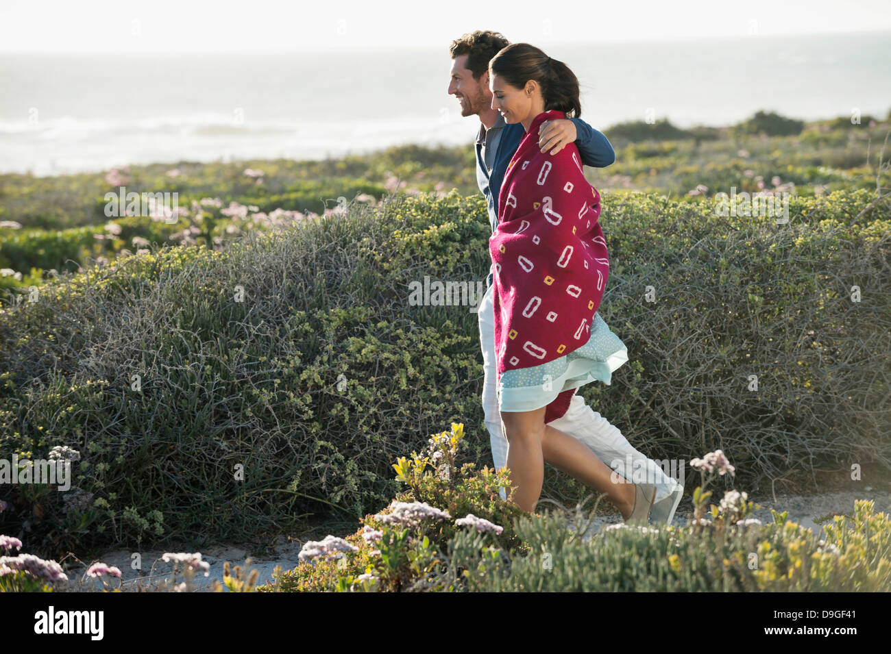 Couple walking on the beach Stock Photo - Alamy
