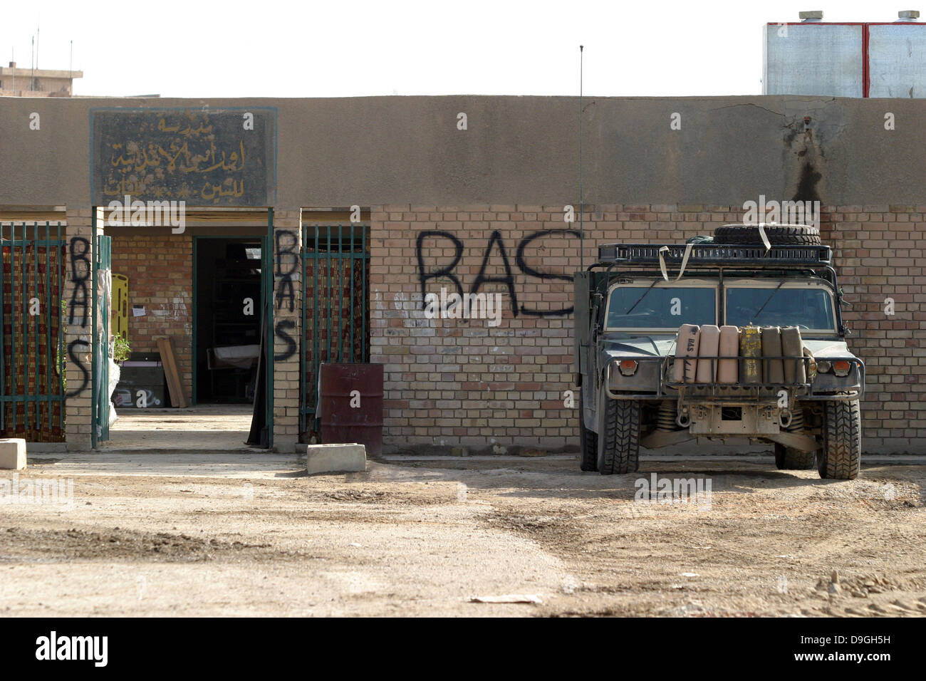 A M998 humvee parked outside an abandoned school. Stock Photo