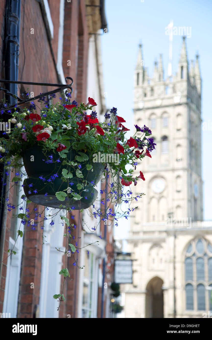 A hanging basket in Church Street Warwick with St. Mary's Church in the background. Stock Photo