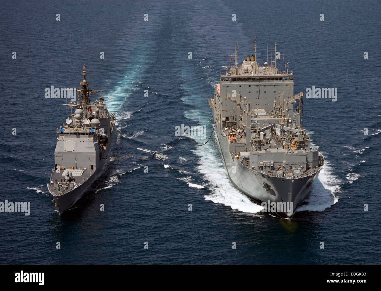 USS Cape St. George pulls alongside USNS Charles Drew for a replenishment at sea. Stock Photo