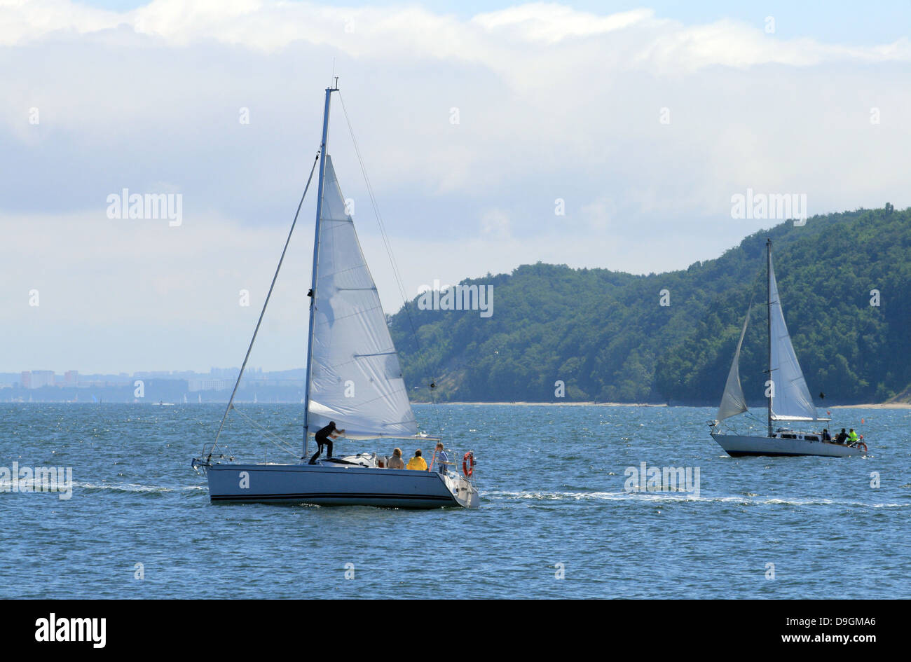 Two sailboats floating on the sea with cliffs in background Stock Photo ...