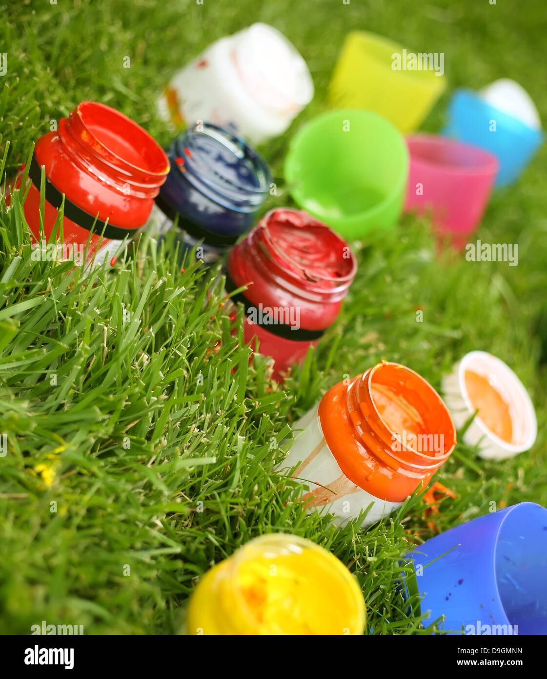 Bright paint colors in the tubes in green grass Stock Photo