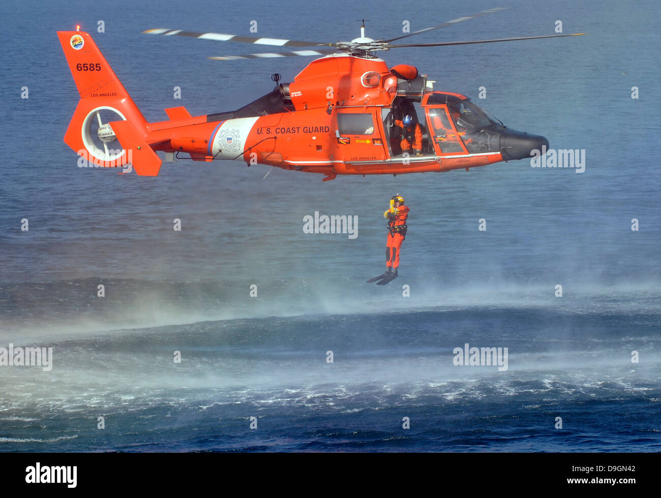 A US Coast Guard rescue swimmer is lowered into the water during training with an aircrew from Coast Guard Air Station Los Angeles November 31, 2012 off the Hermosa Beach Pier, CA. Stock Photo