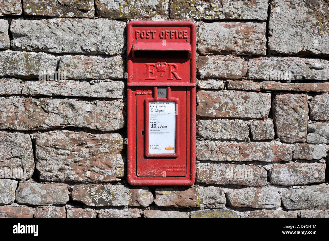 red postbox in sandstone wall Stock Photo