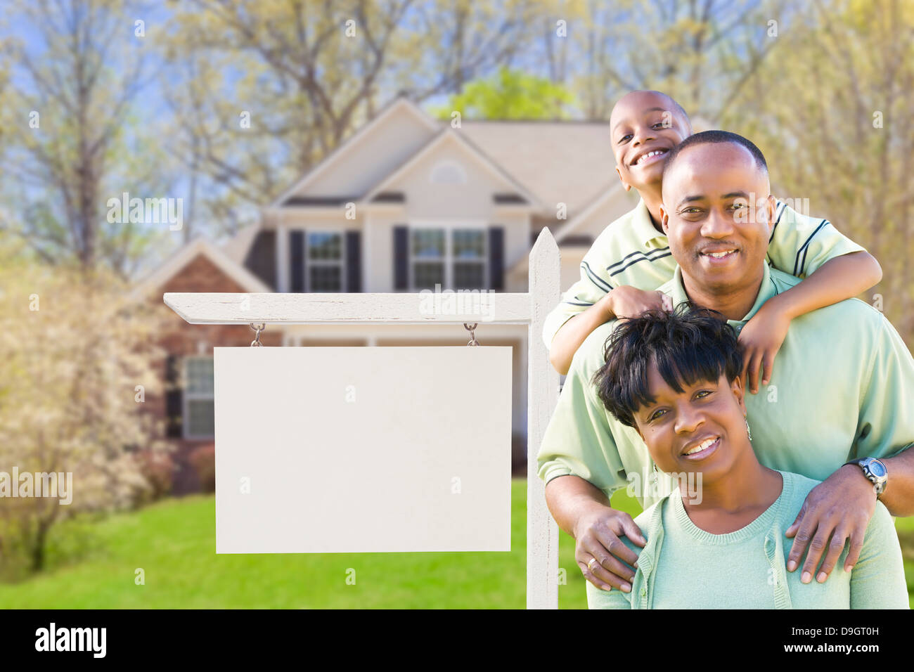 African American Family In Front of Blank Real Estate Sign and New ...