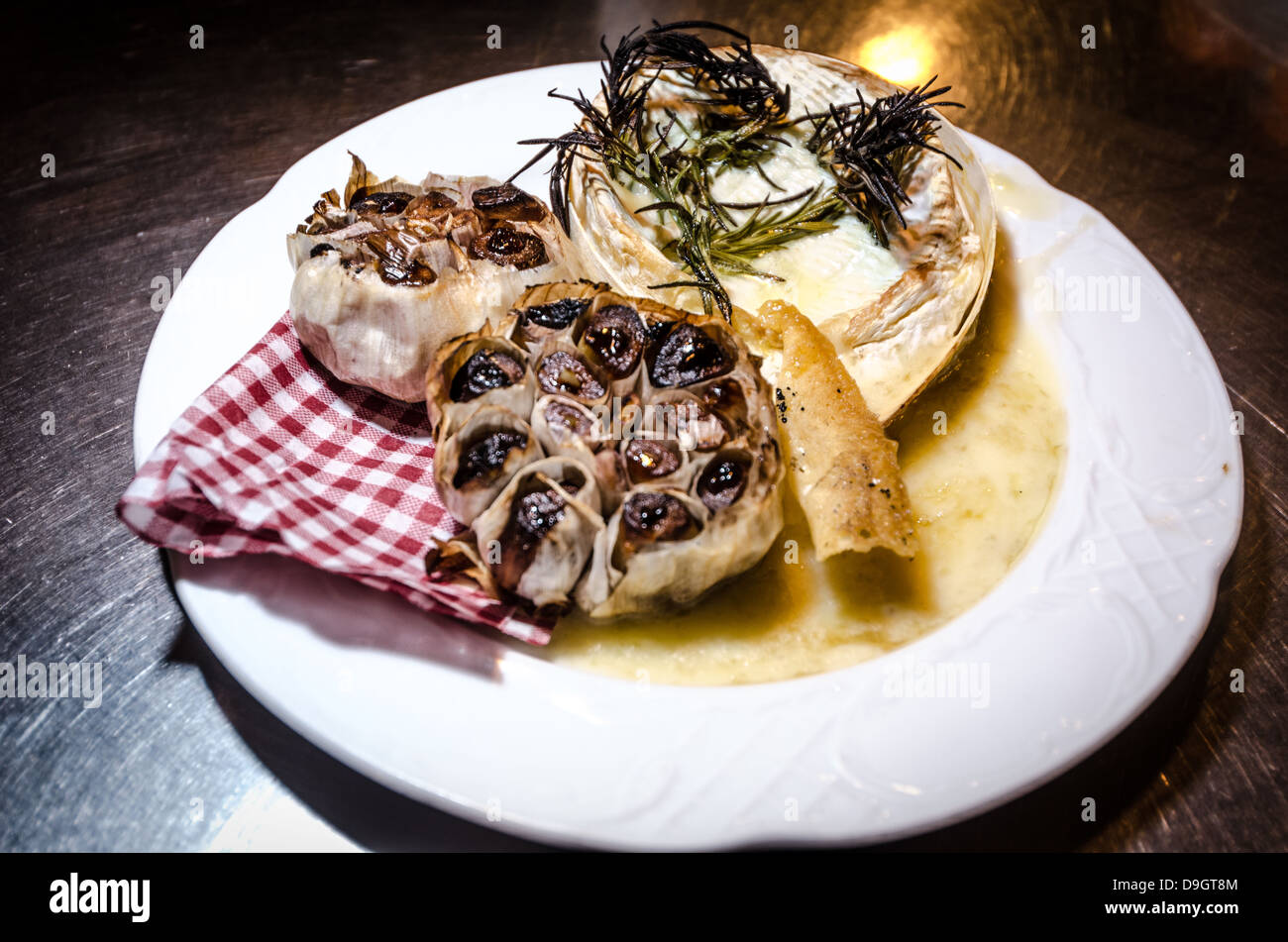 whole Camembert with rosemary and garlic Stock Photo