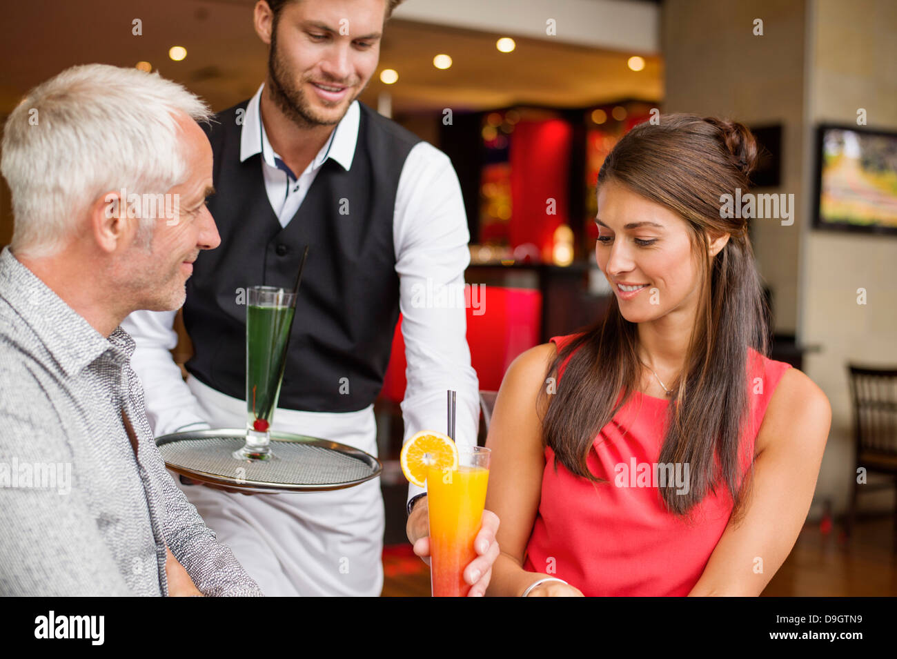 Waiter serving drinks to a couple in a restaurant Stock Photo Alamy