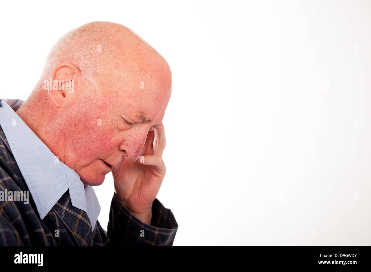 Elderly bald man with is eyes closed and resting his head on his hand ...