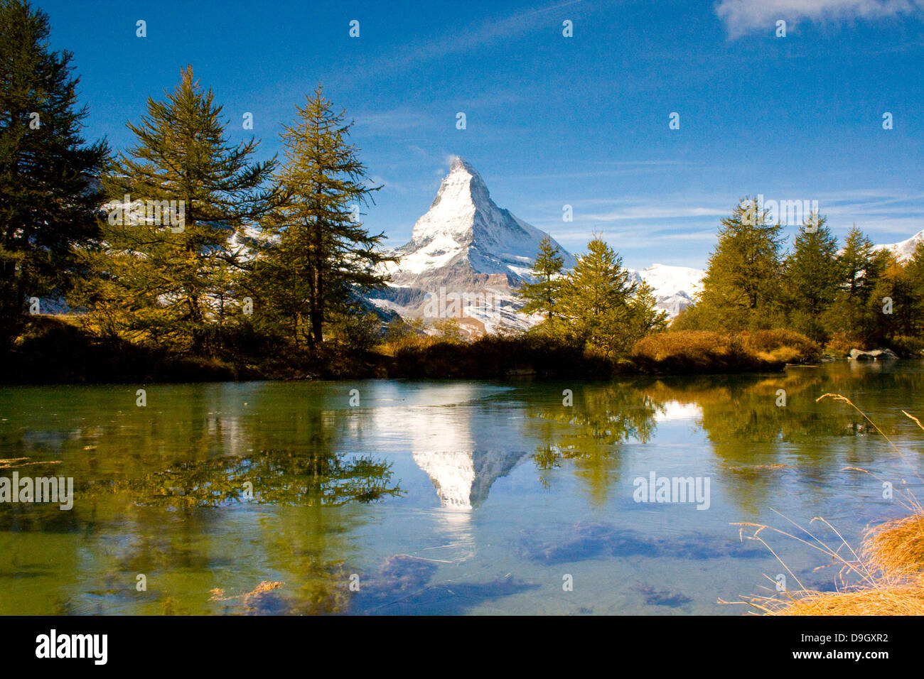 das Matterhorn spiegelt sich im teils vereistem Grindjesee; Matterhorn and its reflection in the partially frozen Grindjesee Stock Photo