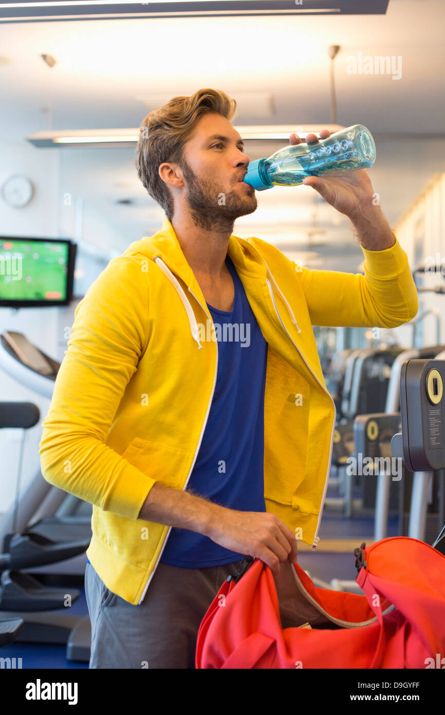 Man drinking water from a bottle in a gym Stock Photo - Alamy