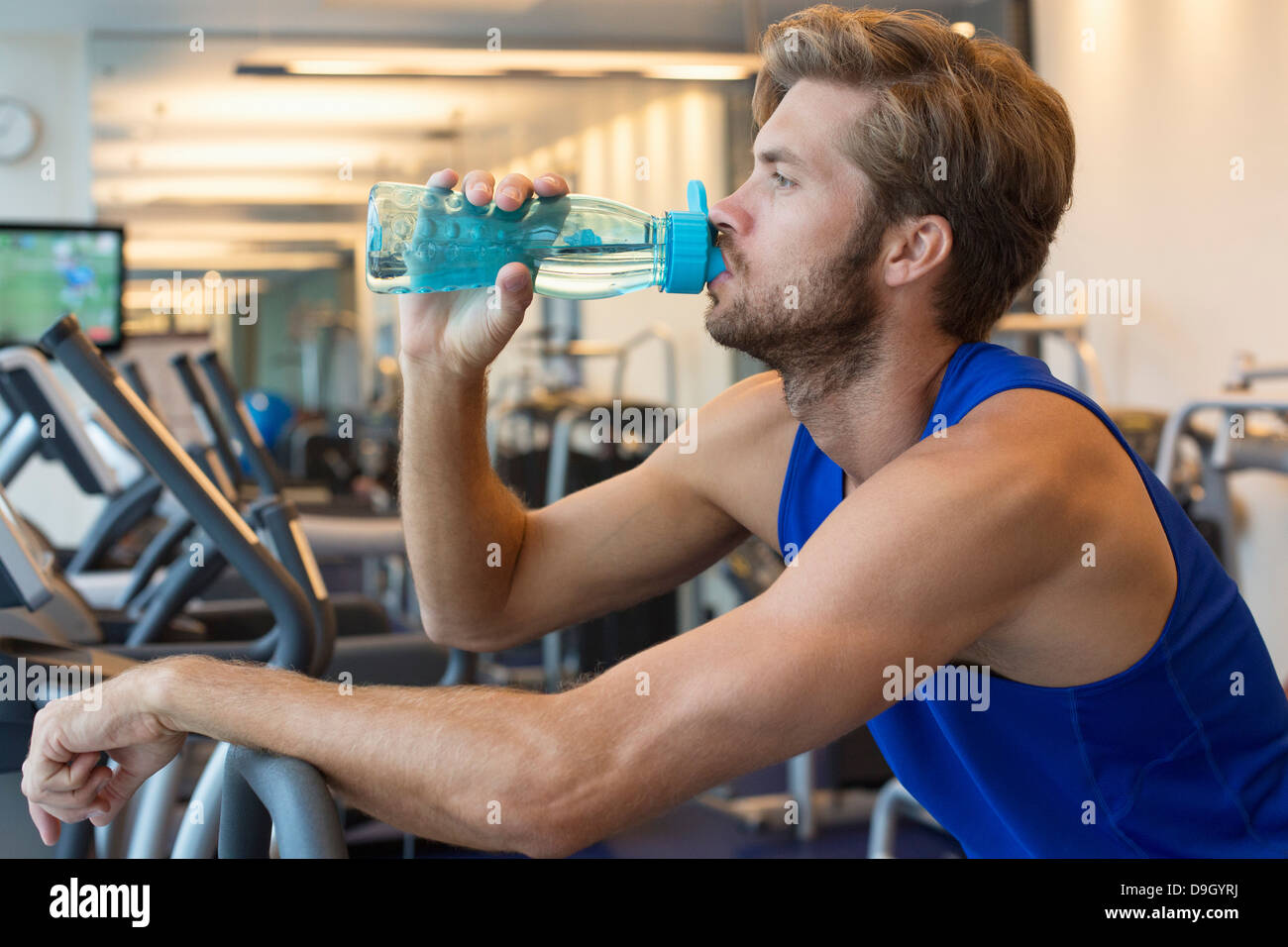 Man drinking water from a bottle at a gym Stock Photo