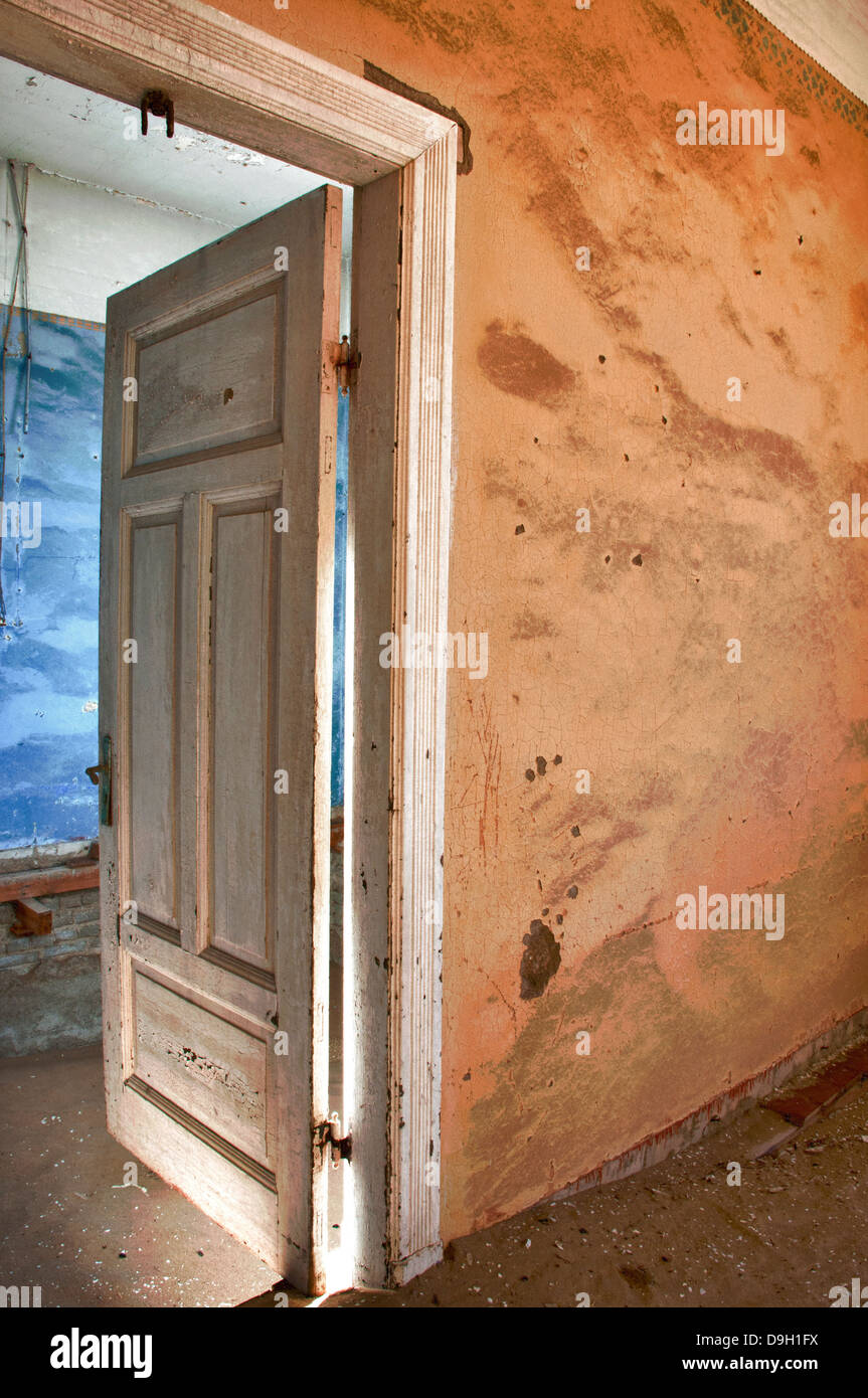 Open door to a room full of sand in Kolmanskop, a ghost mining town in Namibia, Africa. The desert has reclaimed the town. Stock Photo
