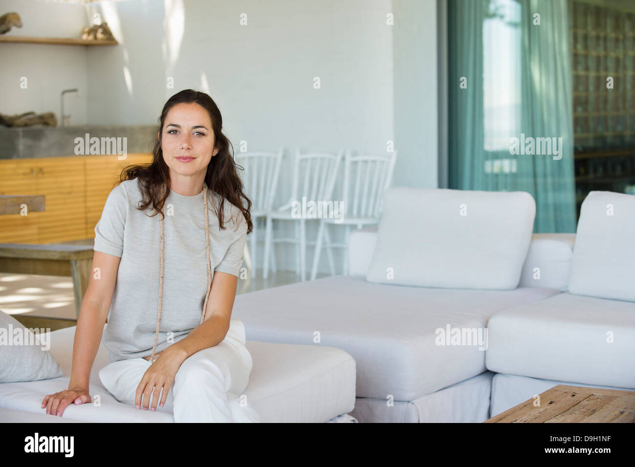 Portrait of a beautiful woman sitting on a couch Stock Photo - Alamy