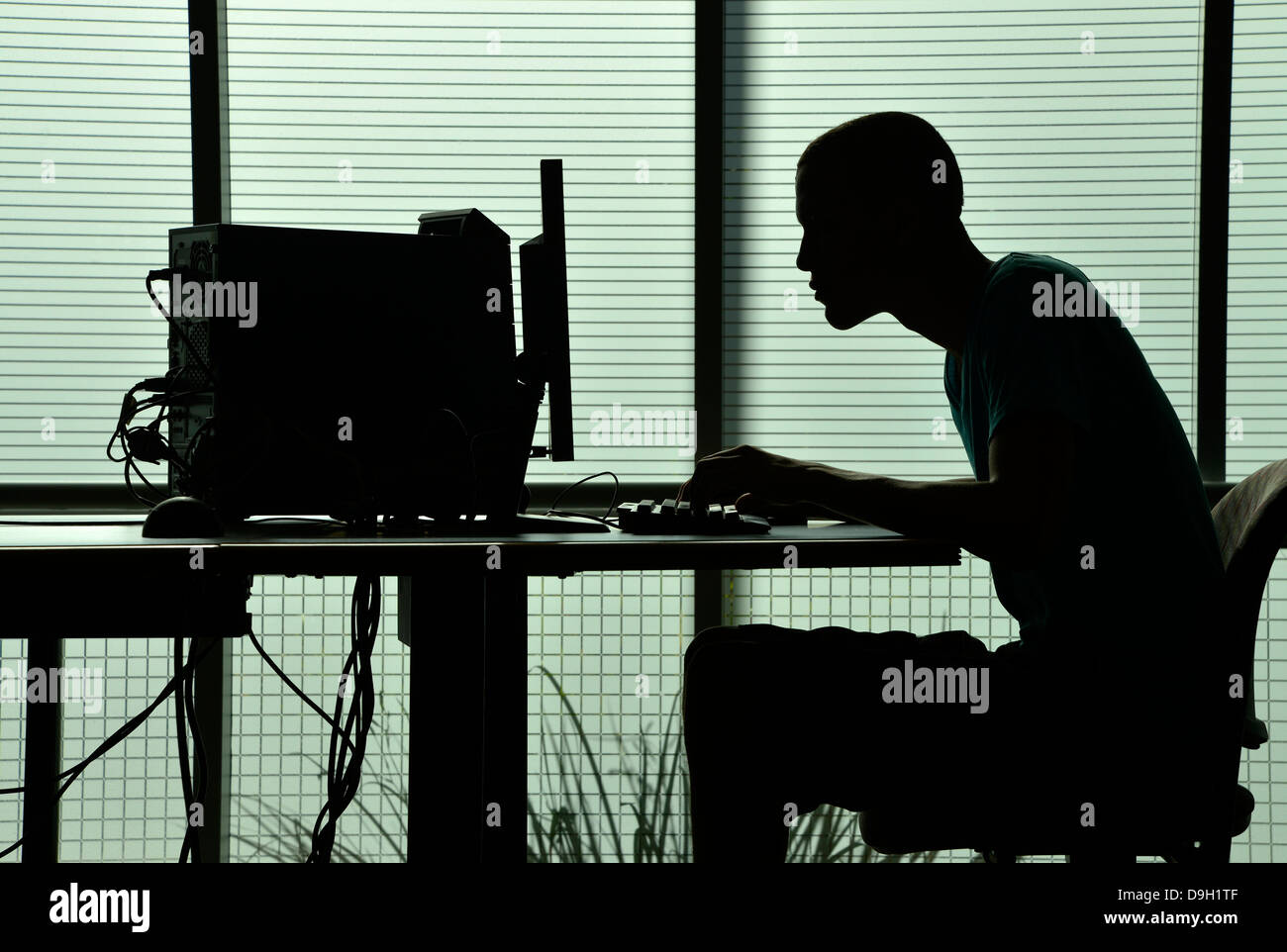 A young man works on a computer on a college campus. Stock Photo