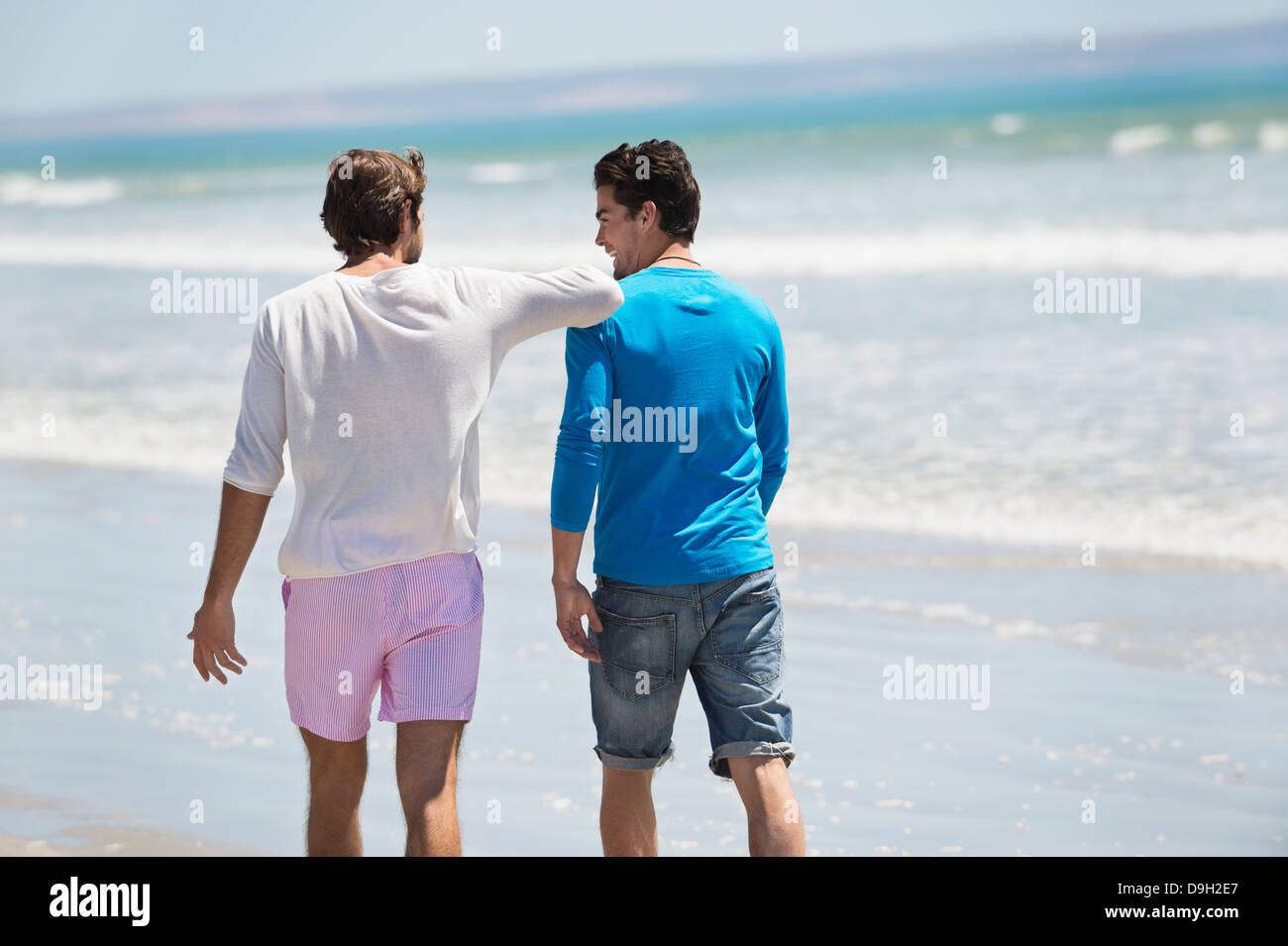 Two men walking on the beach Stock Photo - Alamy