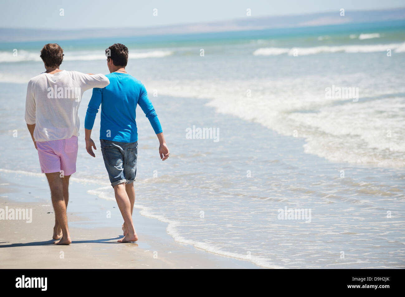 Two men walking on the beach Stock Photo - Alamy