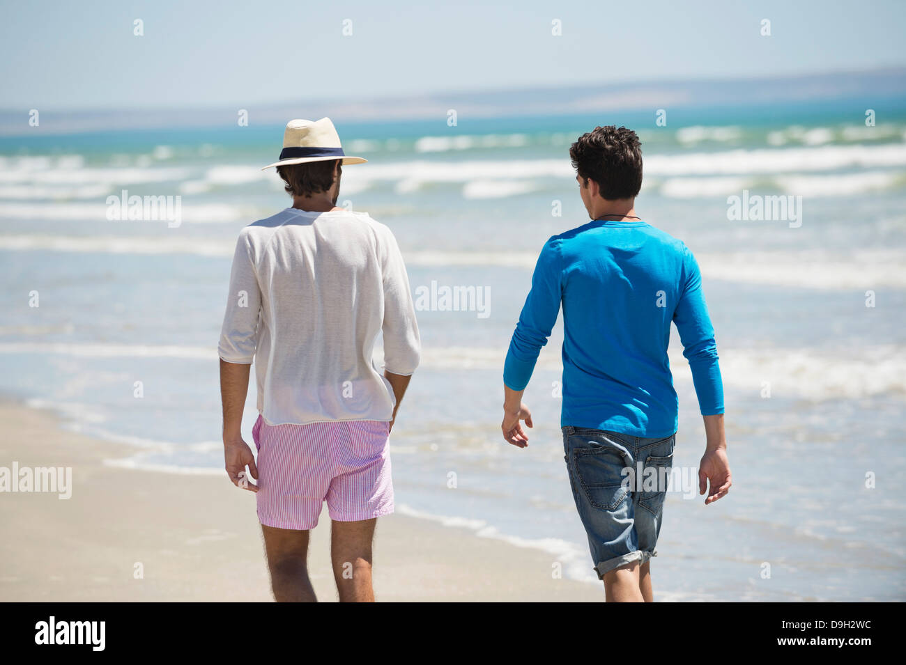 Two men walking on the beach Stock Photo - Alamy