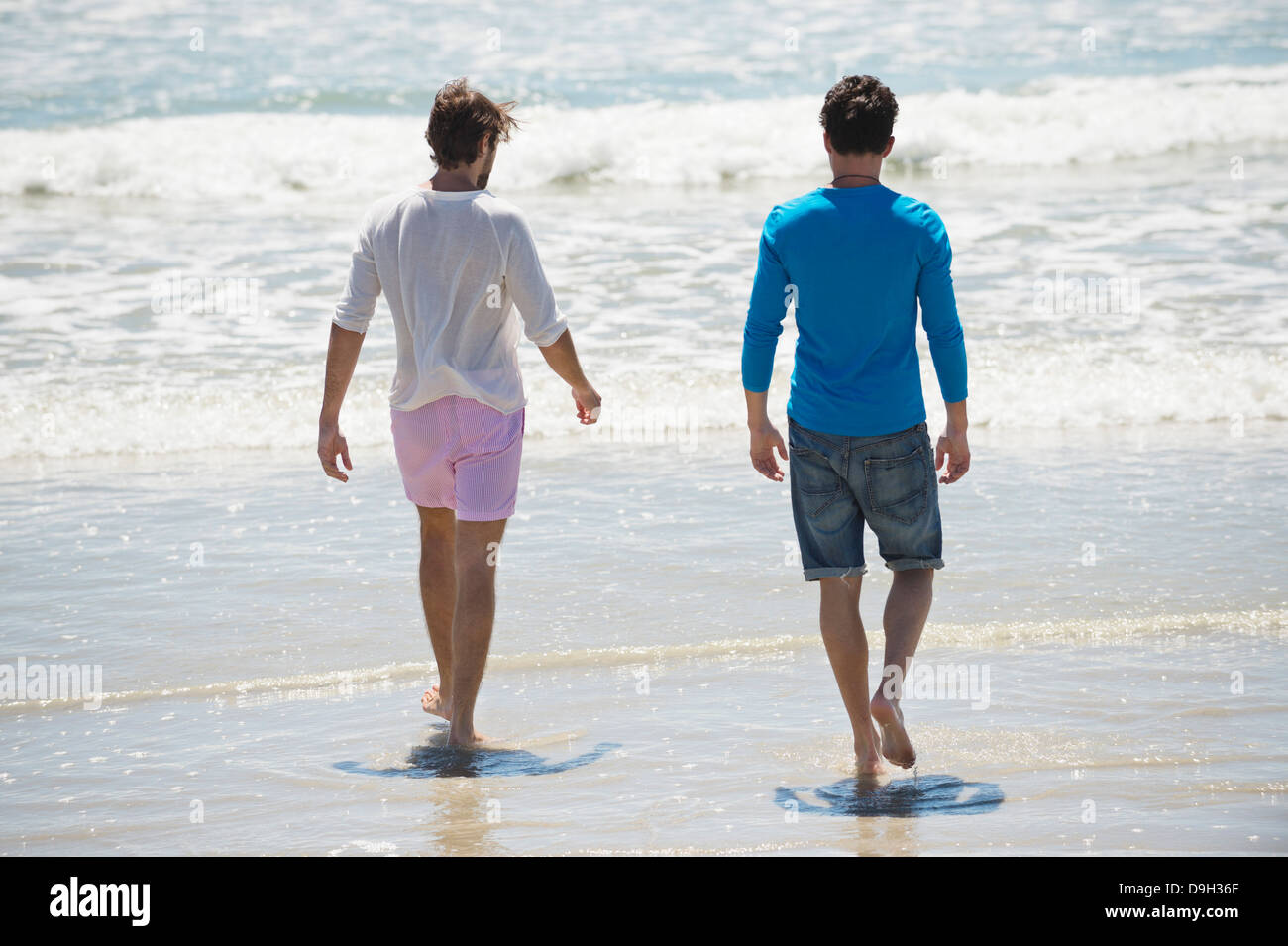 Two men walking on the beach Stock Photo - Alamy