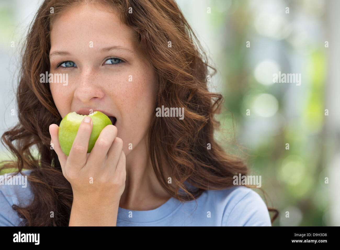 Portrait of a woman eating a green apple Stock Photo Alamy