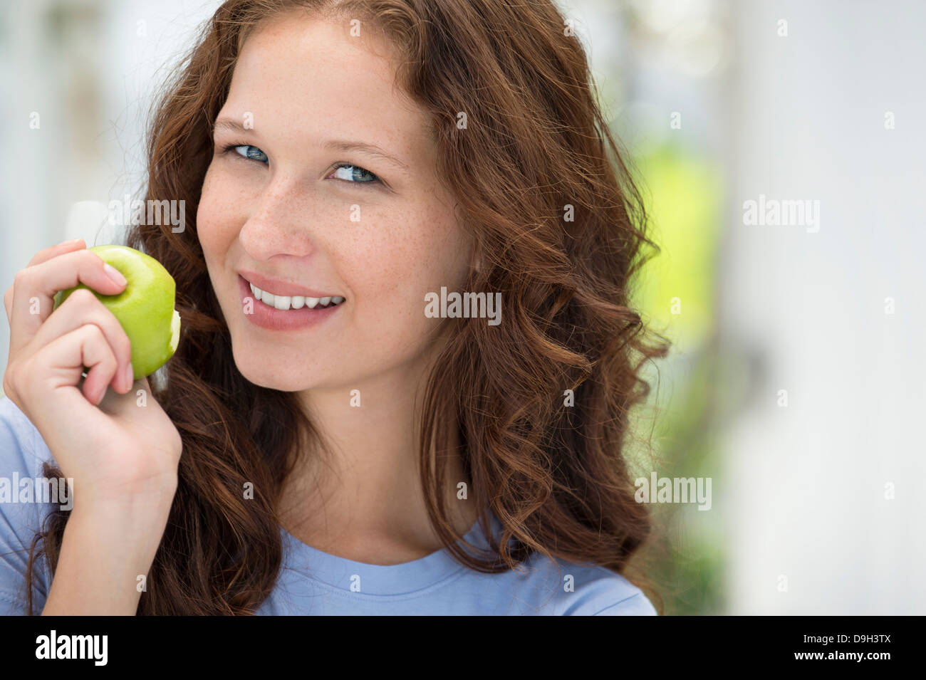 Portrait of a woman eating a green apple Stock Photo Alamy
