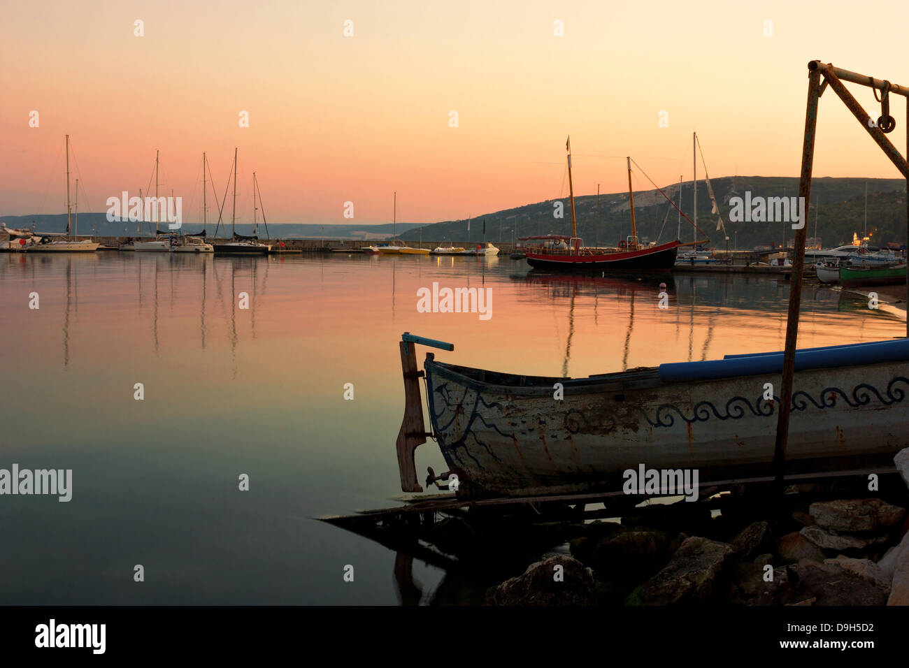 Tranquil sunset scene in a peaceful evening with fishing boats docked in the harbor. Northern Bulgarian Black Sea coast. Stock Photo