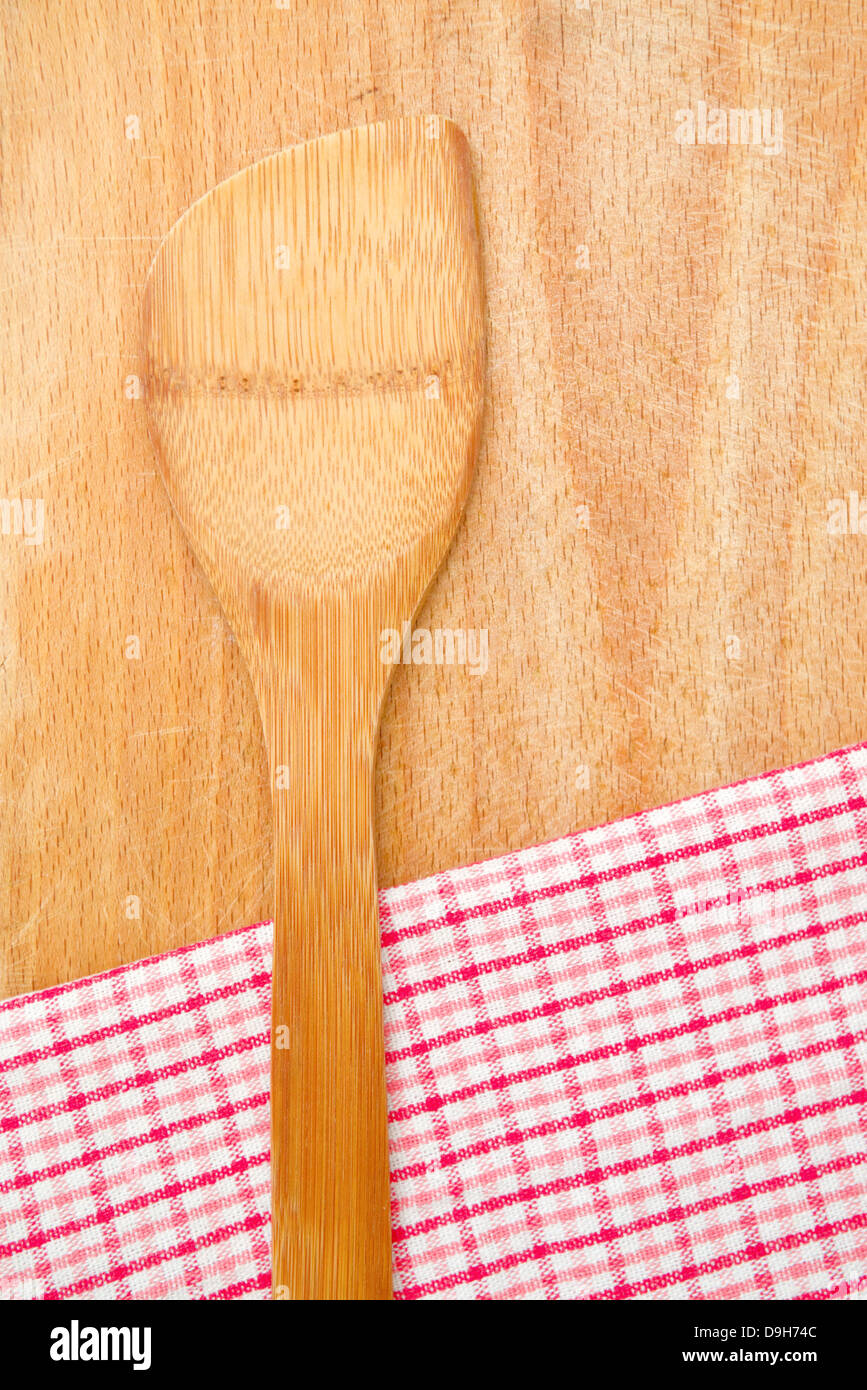 Wooden kitchen utensil and table napkin on wood background. Stock Photo