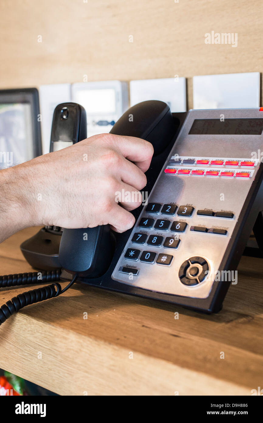Person's hand picking telephone receiver Stock Photo