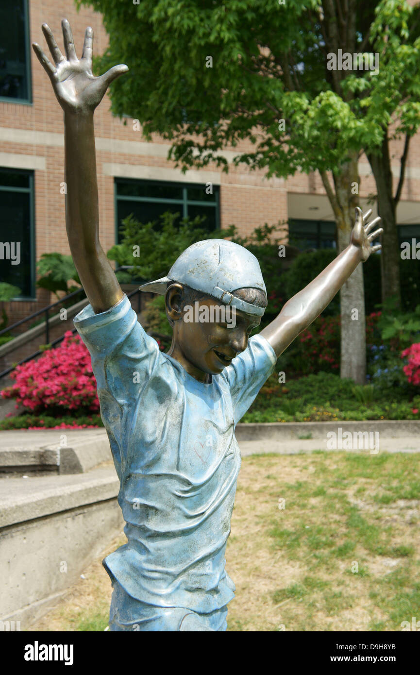 Bronze sculpture of a boy with hands raised in joy, Vancouver, BC, Canada Stock Photo