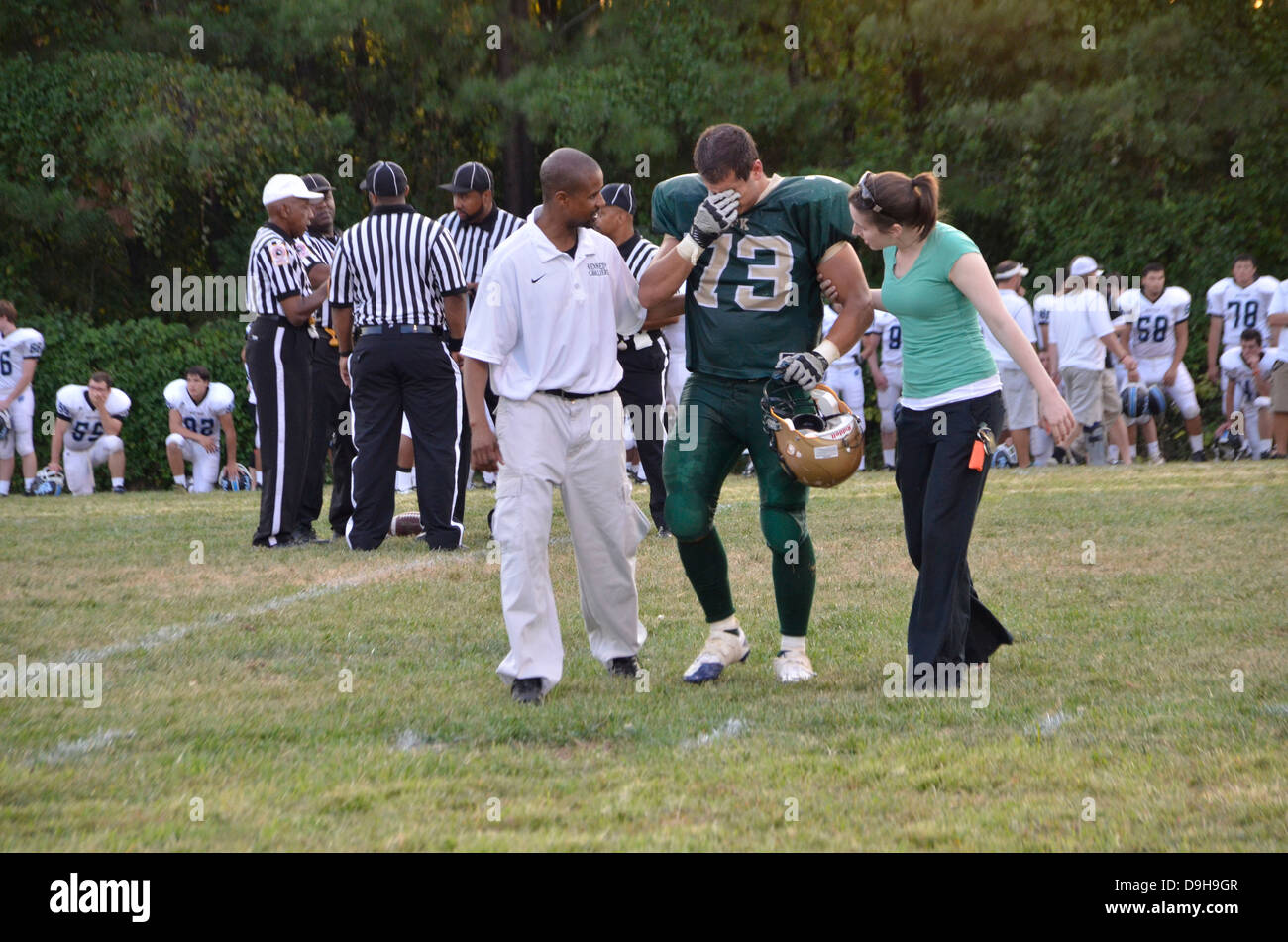 Coach And Medic Help An Injured Player To Get To The Bench