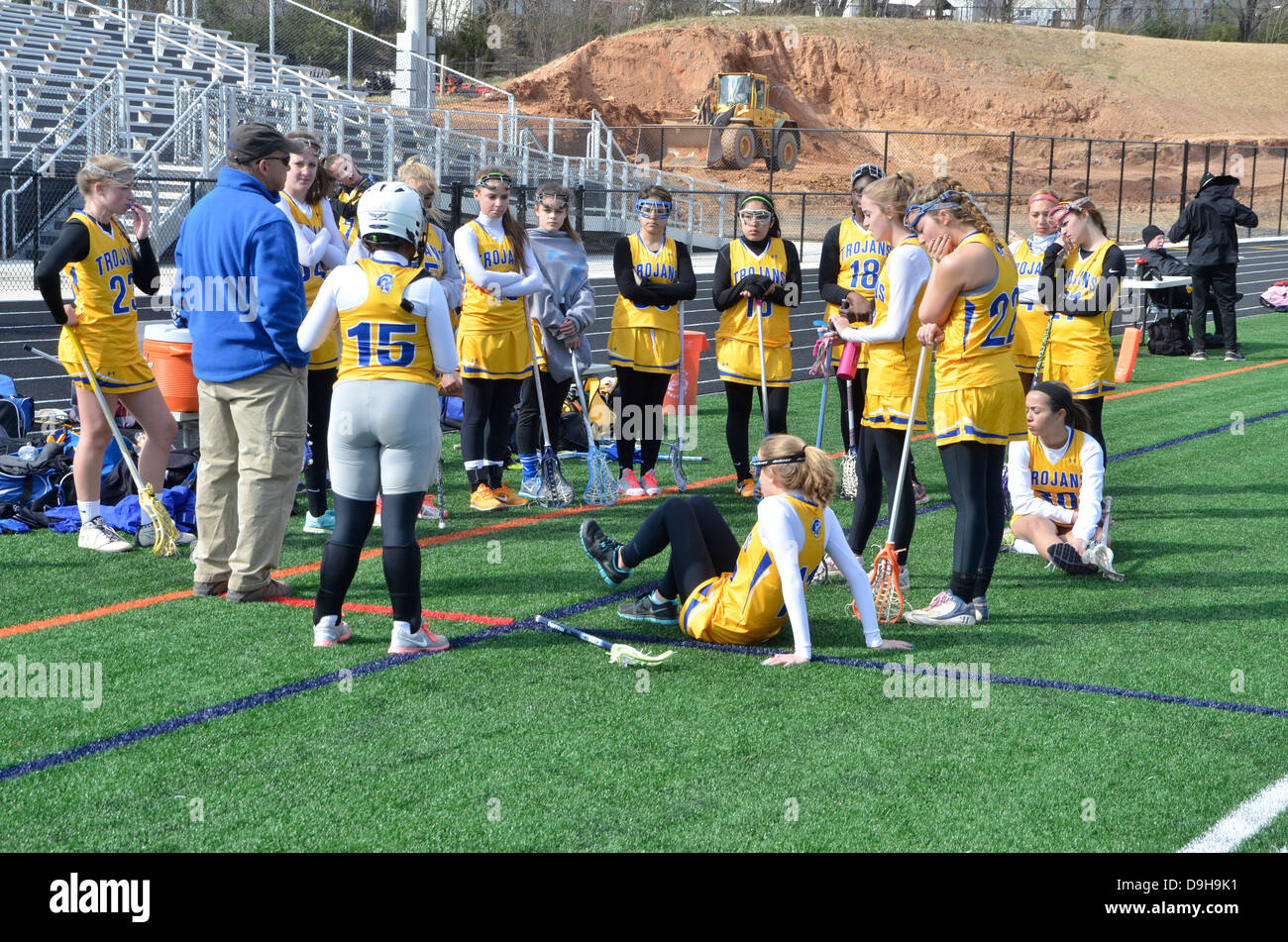 Coach talking and discussing strategy with a female lacrosse team Stock Photo