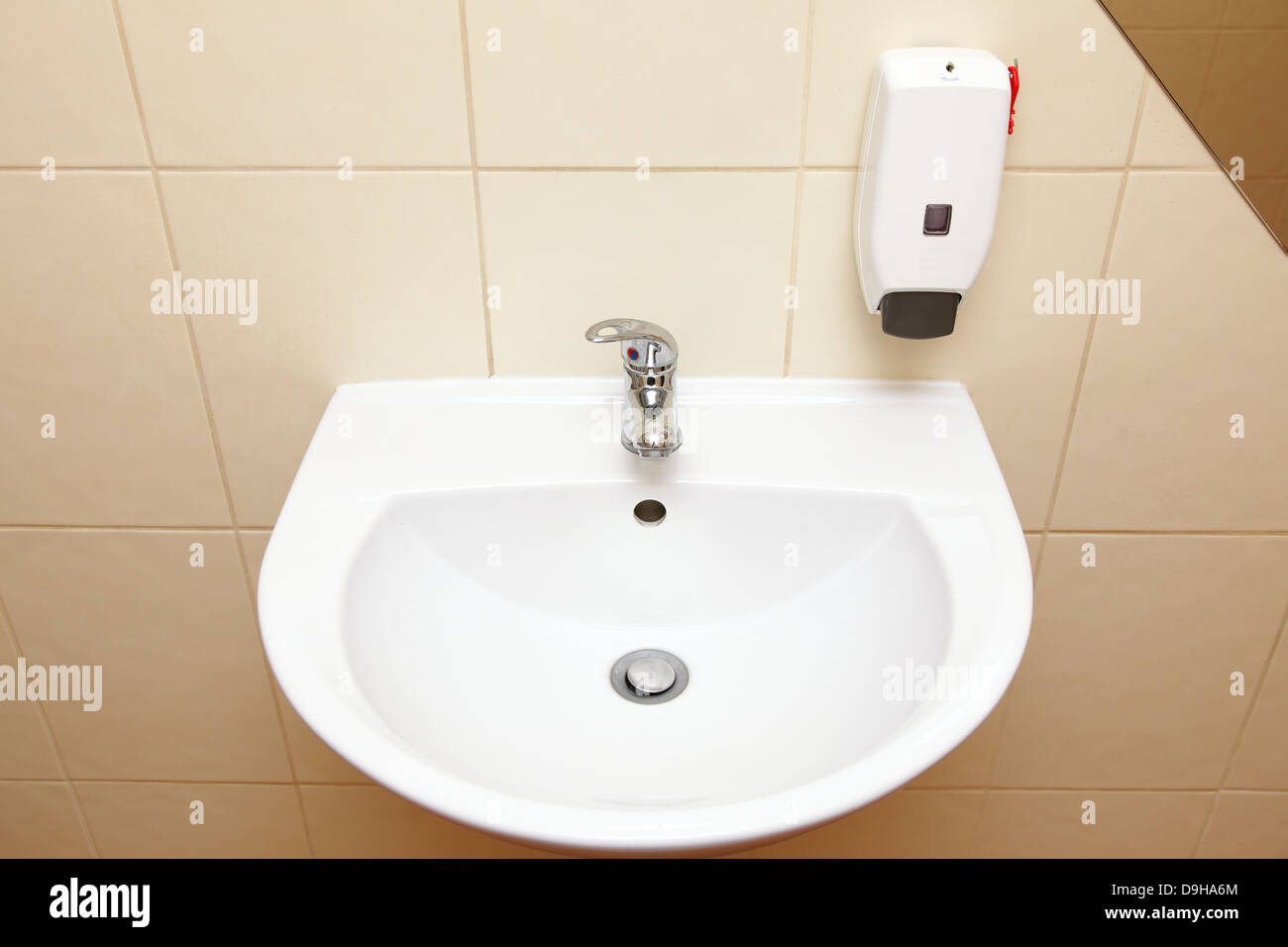 White sink tap and liquid soap in the bathroom Stock Photo