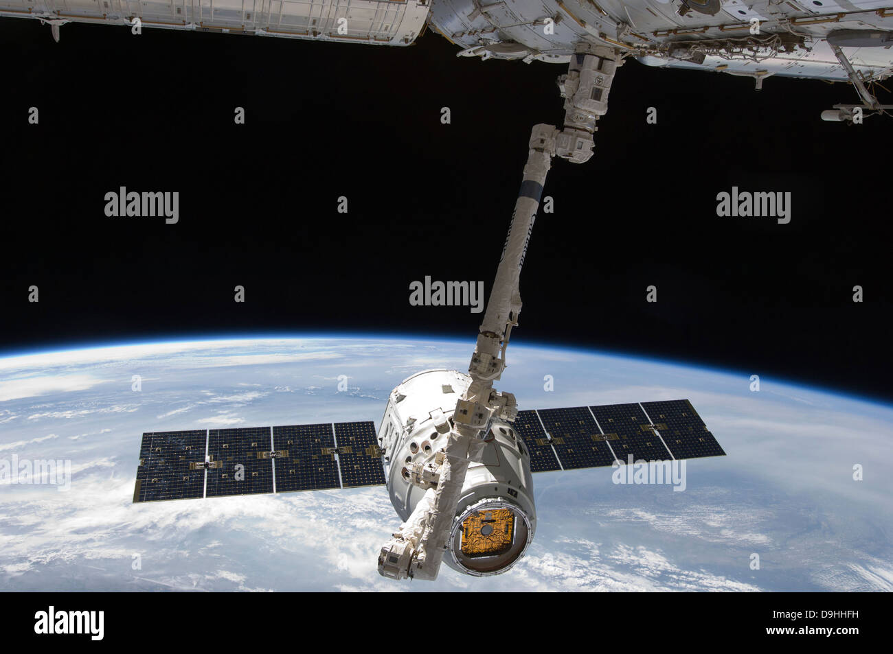 The SpaceX Dragon cargo craft is suspended in the grasp of the Candarm2. Stock Photo