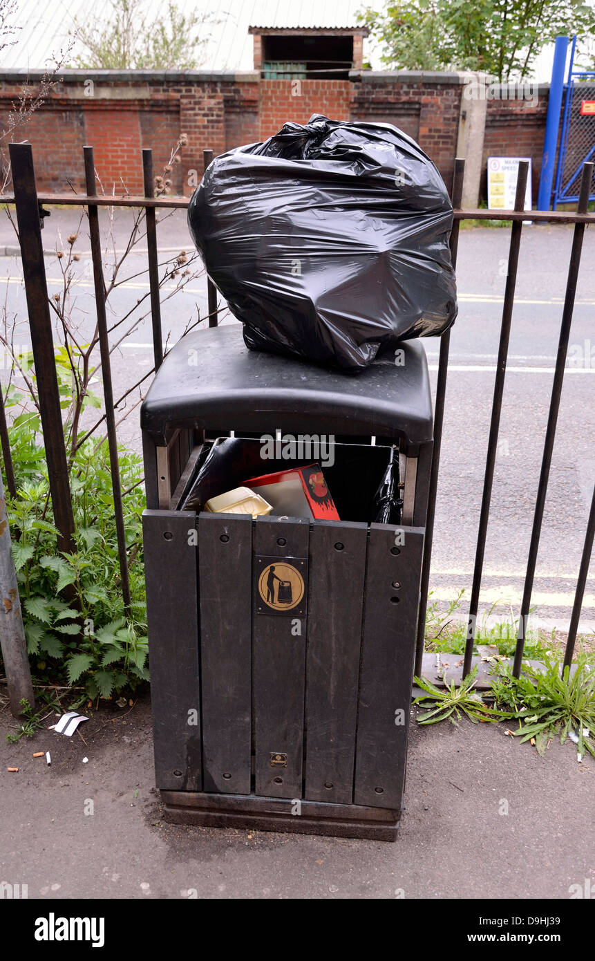 Maidstone, Kent, England. Black bin bag left on top of litter bin Stock