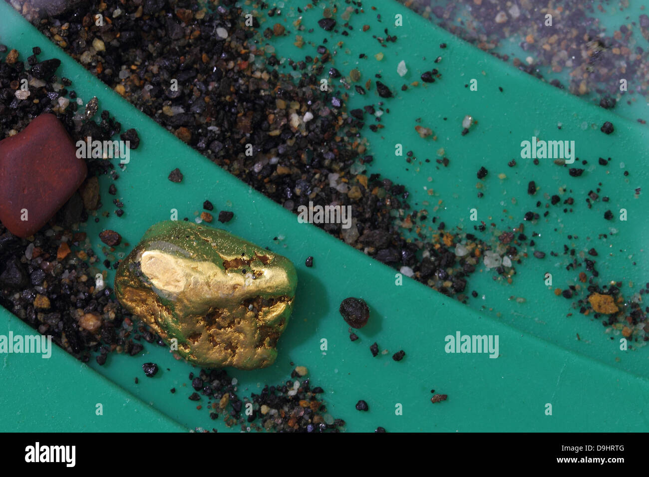 Natural Alaskan (USA) Placer Gold Nugget in Riffles of Gold Pan Stock