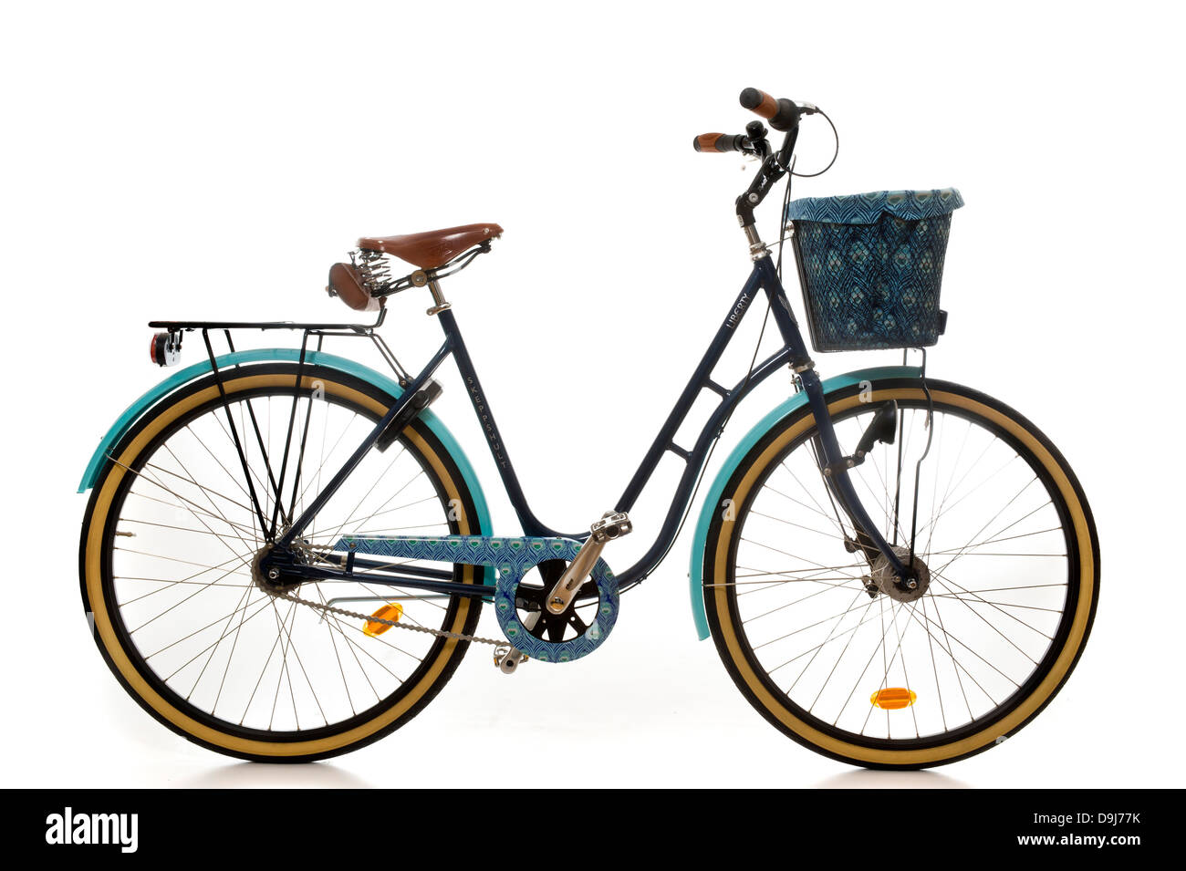 Side view of a traditional ladies bicycle with metal basket lined in Liberty Caesar print fabric. Stock Photo