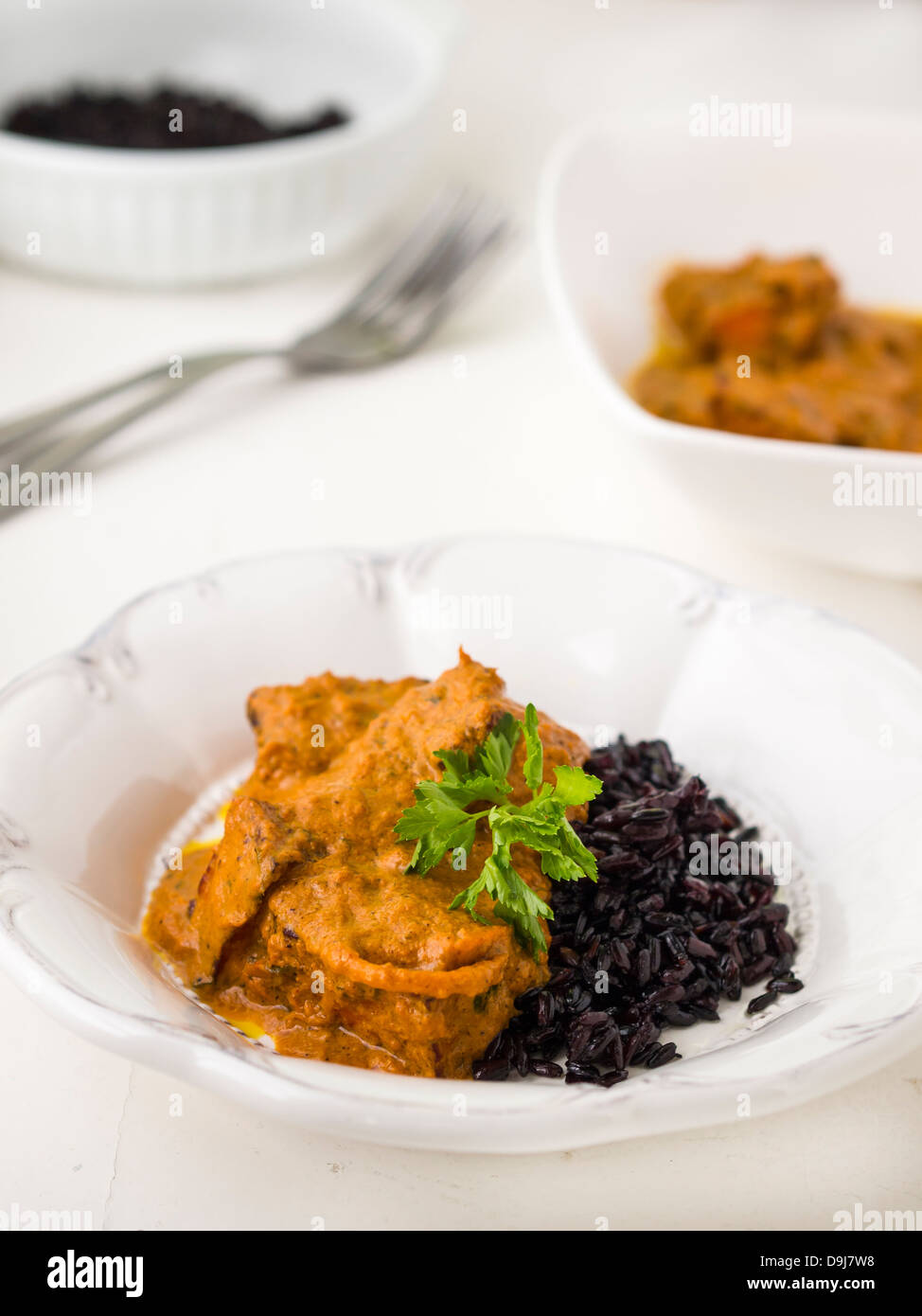 Indian cuisine: paneer tikka masala with black rice. Stock Photo