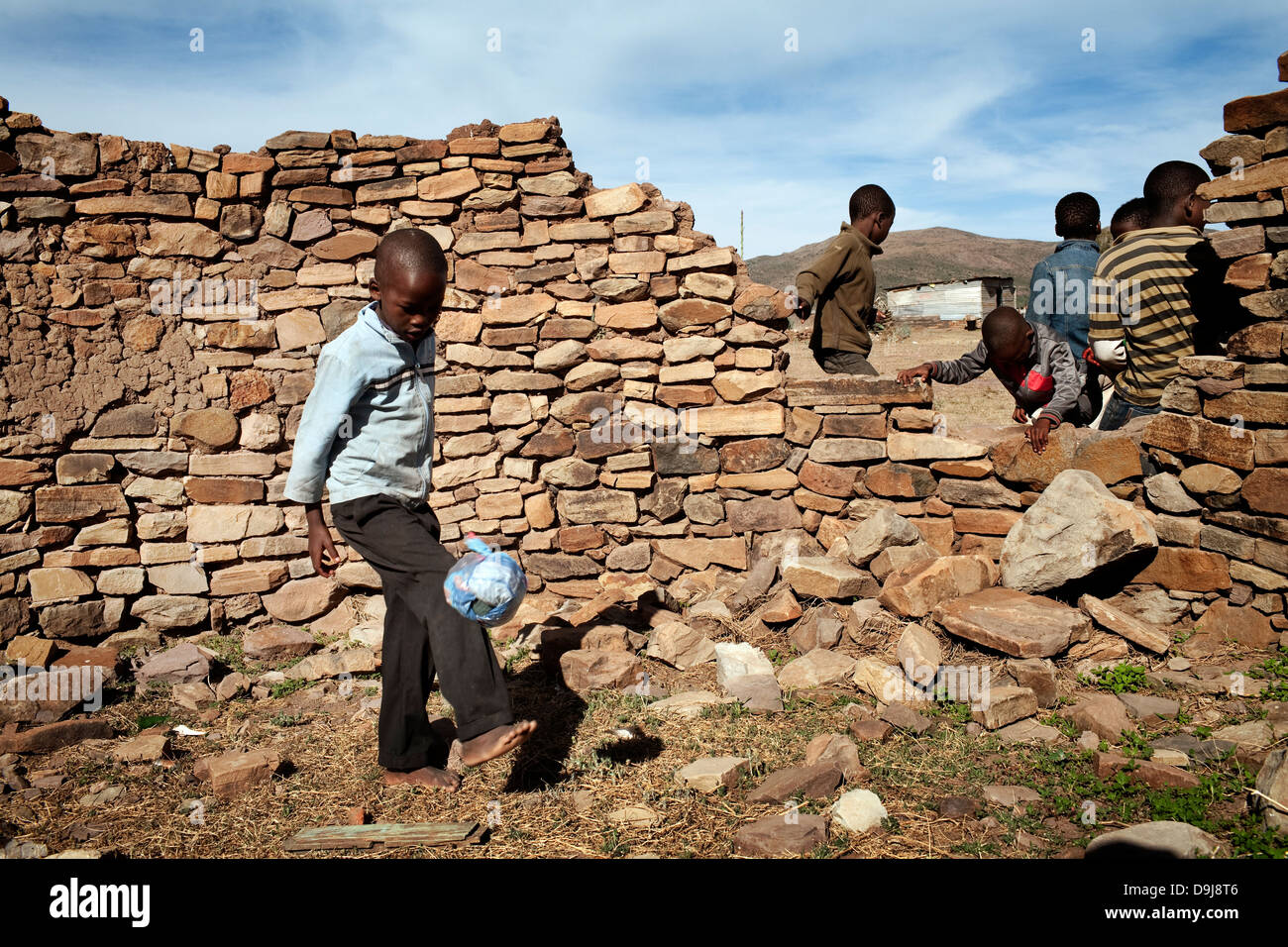 Young boy practices his football skills using a makeshift soccer ball in rural Transkei, South Africa Stock Photo
