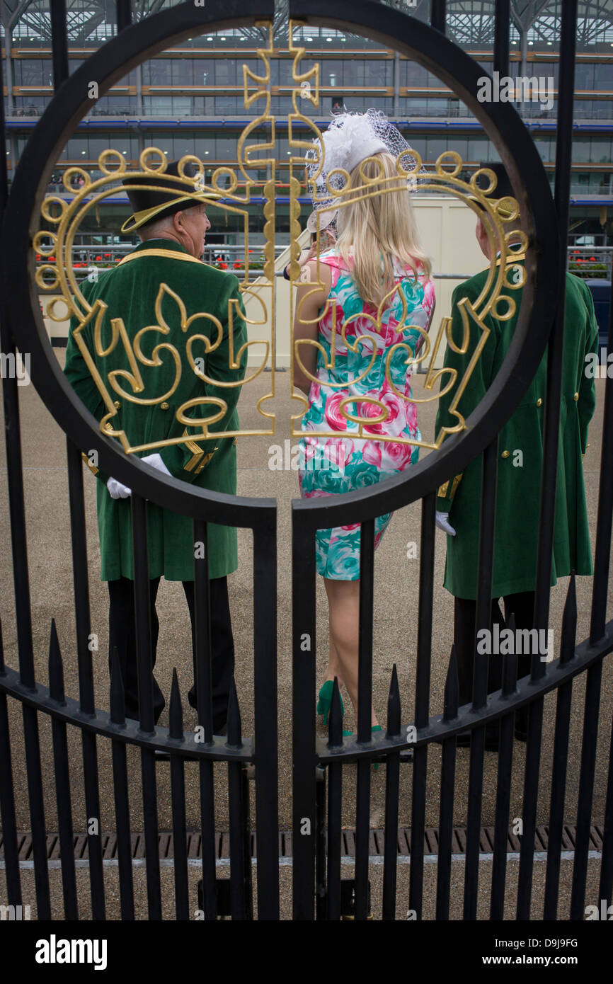 A lady poses with official gatekeepers during the annual Royal Ascot horseracing festival in Berkshire, England. Royal Ascot is one of Europe's most famous race meetings, and dates back to 1711. Queen Elizabeth and various members of the British Royal Family attend. Held every June, it's one of the main dates on the English sporting calendar and summer social season. Over 300,000 people make the annual visit to Berkshire during Royal Ascot week, making this Europe’s best-attended race meeting with over £3m prize money to be won. Stock Photo