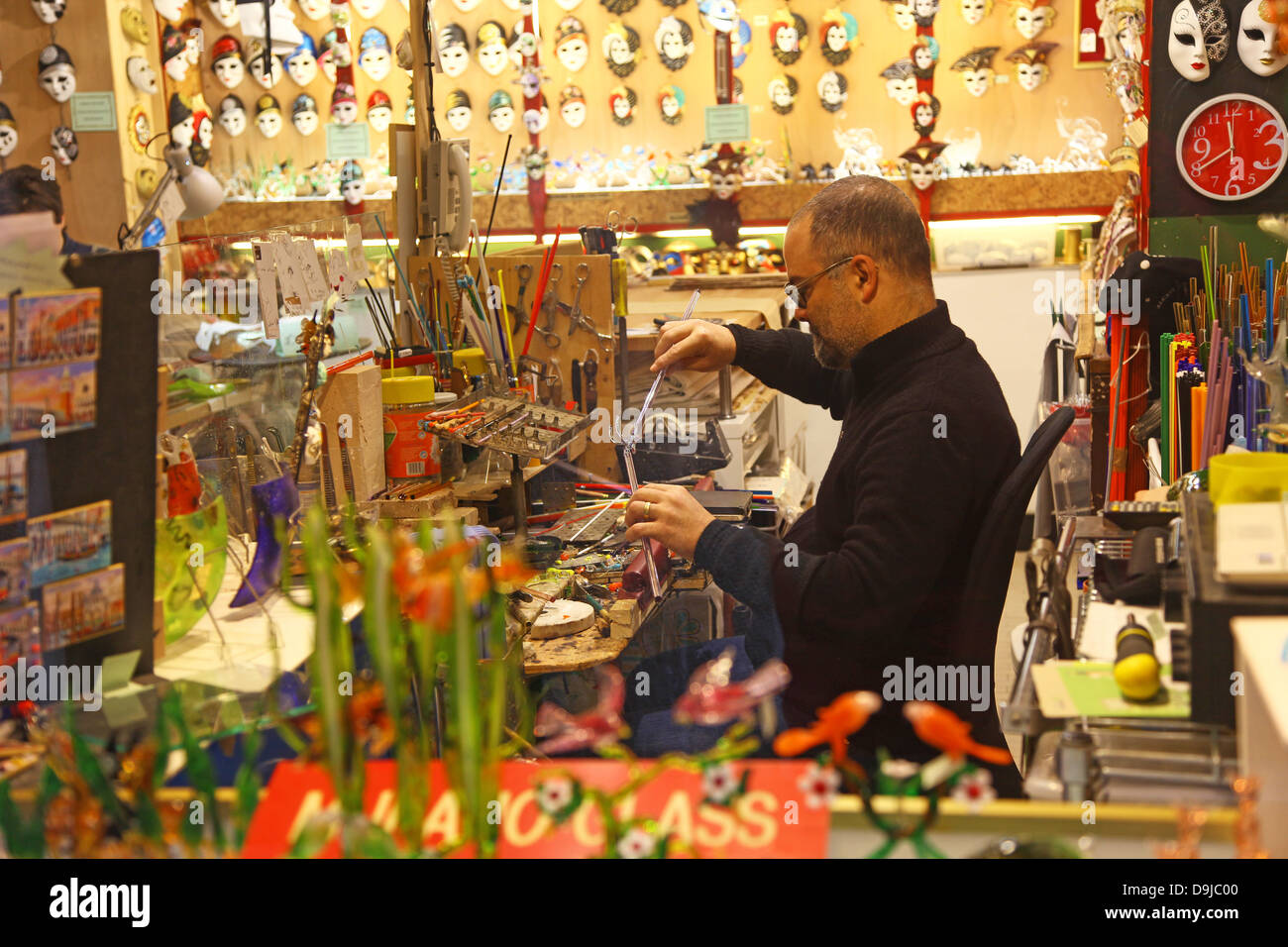 A man in a glass shop making a glass ornament  Murano Venice Italy Stock Photo